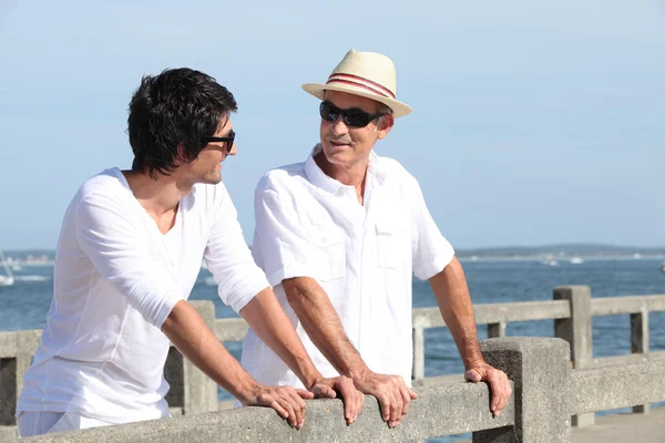 Far och son stod på strandpromenaden — Stockfoto