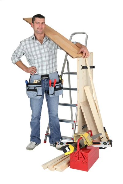 Craftsman holding a wooden floor board — Stock Photo, Image