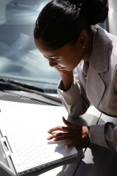 Podnikatelka používání notebooku na její auto kapoty — Stock fotografie