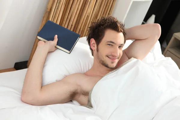 Man relaxing in his bed Royalty Free Stock Images