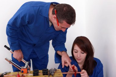Craftsman giving explanations to his apprentice clipart