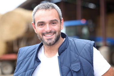 A farmer in front of a tractor clipart