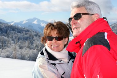 Mature couple on a skiing holiday clipart