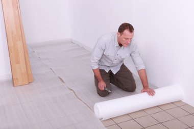 Handyman putting tarpauling on the floor clipart