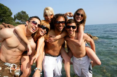 Group of young friends having fun at the seaside clipart