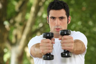 Young man doing fitness in a park clipart