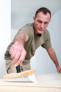 Man applying wallpaper paste clipart