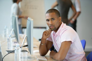 Casual man using a computer in an office clipart