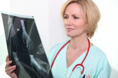 Female medic looking at x-rays clipart