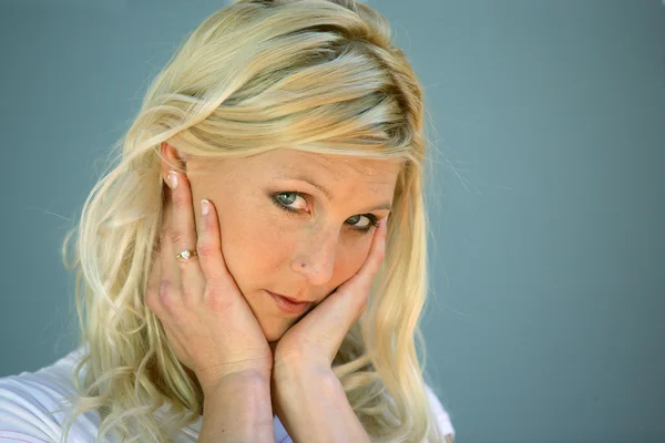 Blond woman touching her face — Stock Photo, Image