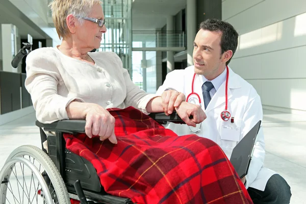 Arzt im Gespräch mit einer Frau im Rollstuhl — Stockfoto