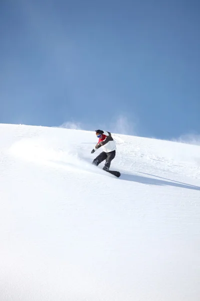 Um snowboarder deslizando por uma encosta — Fotografia de Stock