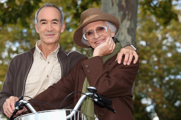 Older couple with a bicycle — Stock Photo, Image