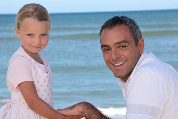 父亲和女儿手牵手在沙滩上 — 图库照片