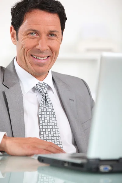 Hombre de negocios satisfecho delante de la computadora portátil —  Fotos de Stock