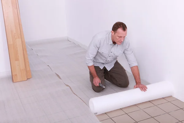 Handyman att sätta tarpauling på golvet — Stockfoto