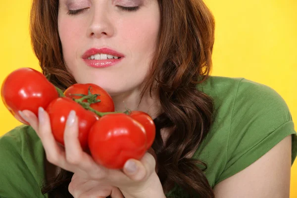 Kvinna att lukta vinstockar tomater — Stockfoto
