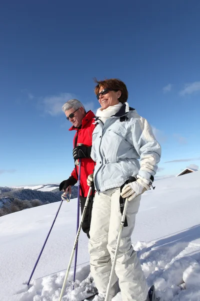 年长的夫妻的滑雪者在雪中行走 — 图库照片