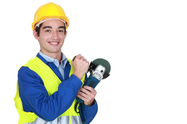 Trabajador sonriente sosteniendo lijadora — Foto de Stock
