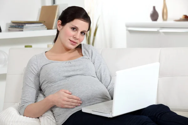 Gravid kvinna vilar laptop på varvet — Stockfoto