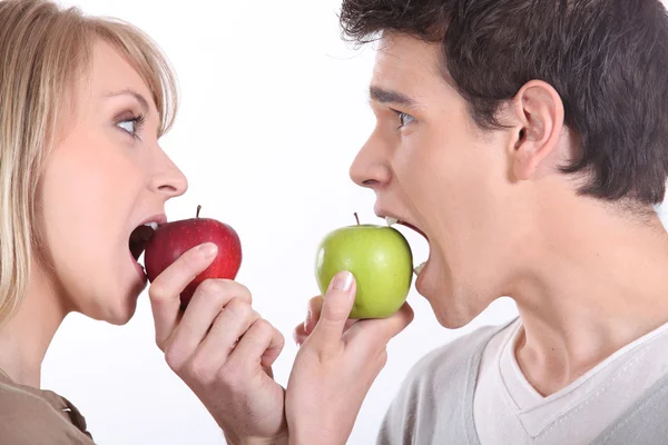 Man and woman about to bite into apples — Stock Photo, Image