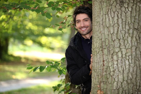 Retrato de um jovem ao lado de uma árvore — Fotografia de Stock