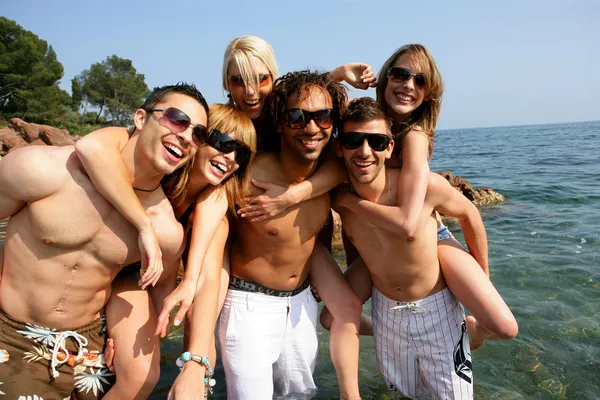 Groep van jonge vrienden plezier aan zee — Stockfoto