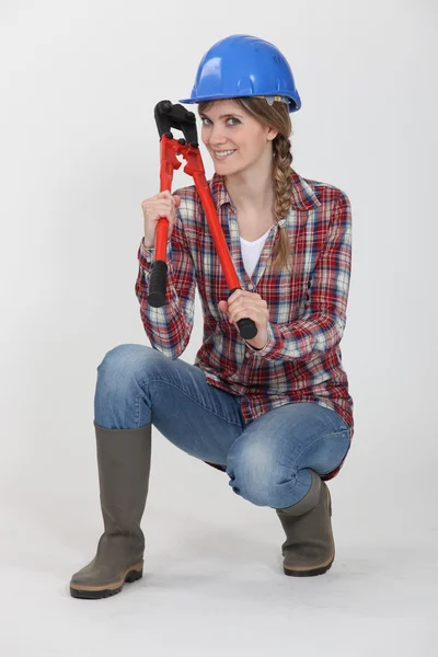 Mulher segurando cortador de parafuso enquanto em posição de agachar — Fotografia de Stock