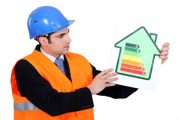 Foreman holding panel of energy consumption ranking — Stock Photo, Image
