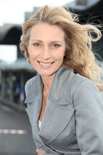 Mujer de negocios sonriendo con viento en el pelo —  Fotos de Stock