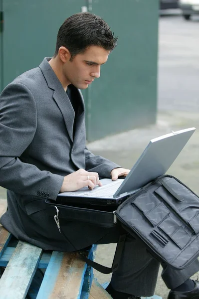 Biznesmen siedział na zewnątrz z jego laptop — Zdjęcie stockowe