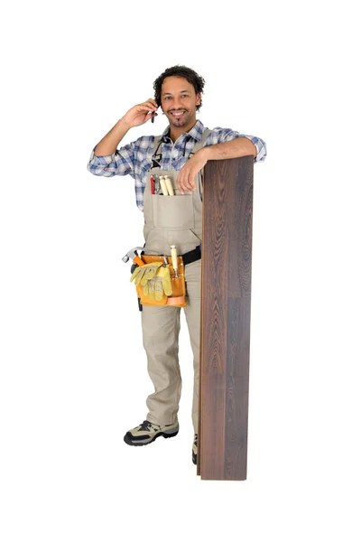 Man with laminate flooring and cellphone — Stock Photo, Image