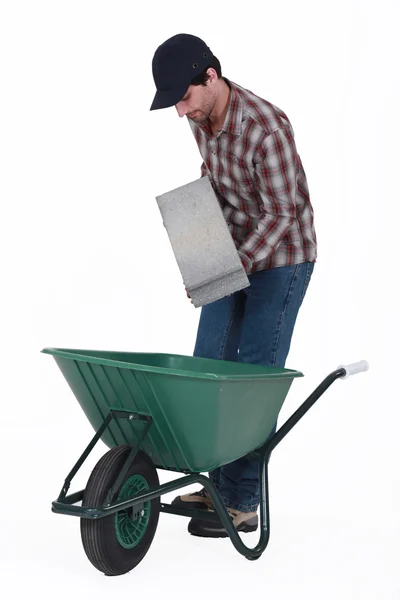 Mattone mettendo blocco di calcestruzzo in carriola — Foto Stock