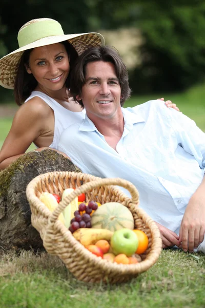 Paar posiert mit Obstkorb — Stockfoto