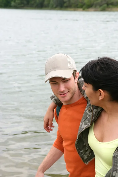 Young couple walking by a river — Stock Photo, Image