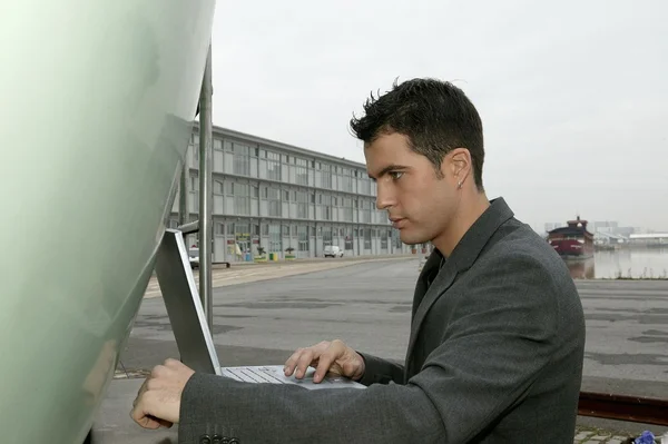 Muž v obleku s přenosným počítačem — Stock fotografie
