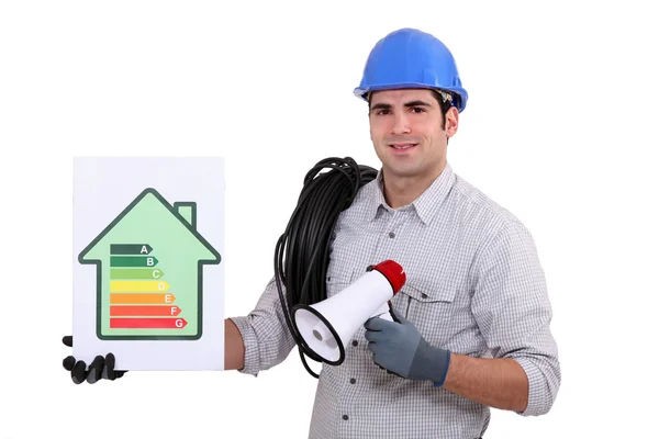 Tradesman segurando um megafone e um gráfico de classificação de eficiência energética — Fotografia de Stock