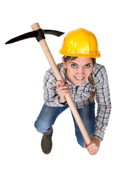 En kvinnlig byggnadsarbetare med en yxa. — Stockfoto