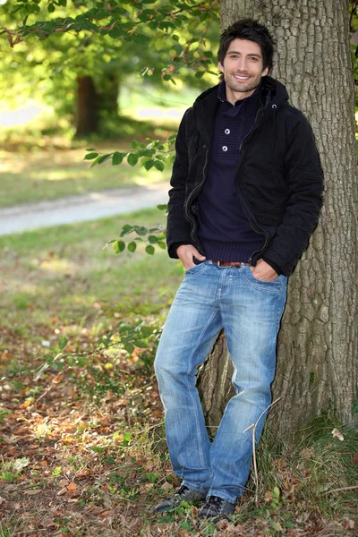 Mladý muž u stromu na podzim — Stock fotografie