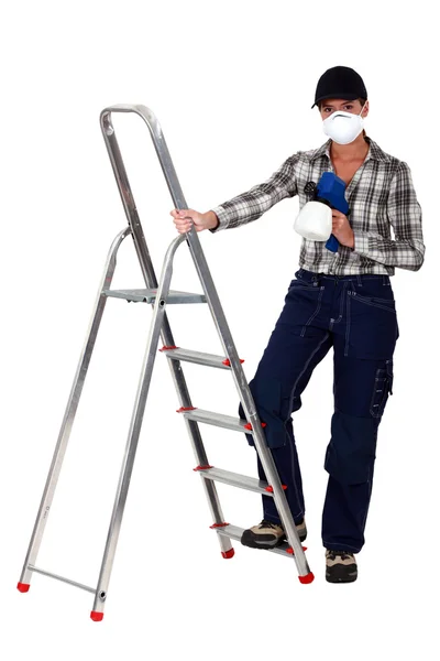 Comerciante segurando uma pistola de pulverização e de pé ao lado de uma escada rolante — Fotografia de Stock