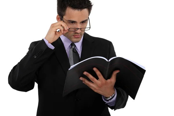 Muž přes brýle a drží knihu — Stock fotografie