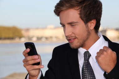 Young executive pleased with his phone message clipart