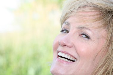 Facial closeup of a smiling woman with a wide grin clipart