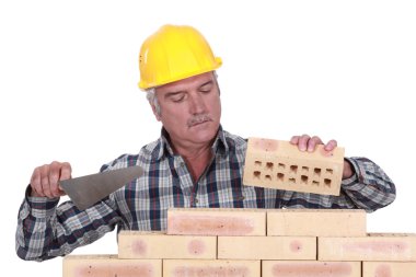 Bricklayer laying bricks clipart