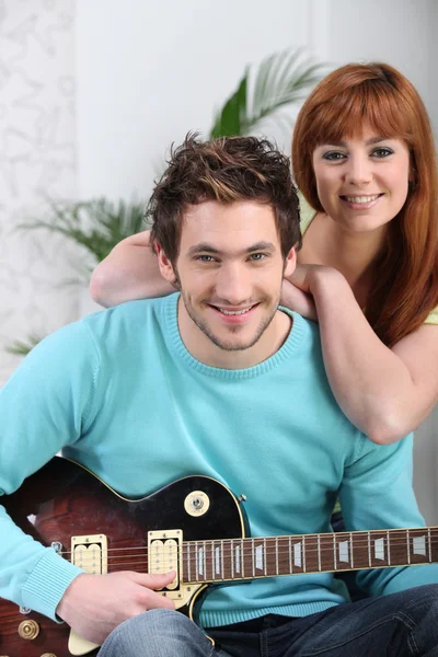 Un homme jouant de la guitare et sa petite amie — Photo