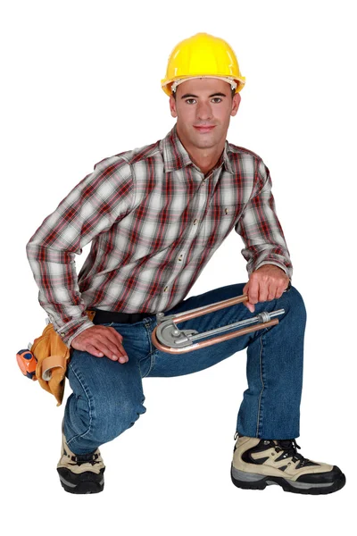 Tradesman segurando um dobrador de tubo — Fotografia de Stock