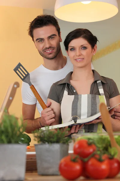 Dvojice v kuchyni s kuchařkou — Stock fotografie