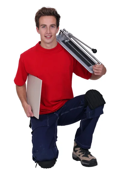 Young handyman posing with a tile cutter and a tile — Stock Photo, Image