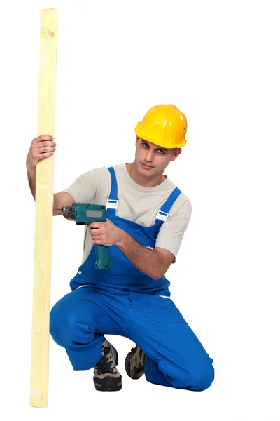 Man drilling hole in to plank of wood — Stock Photo, Image