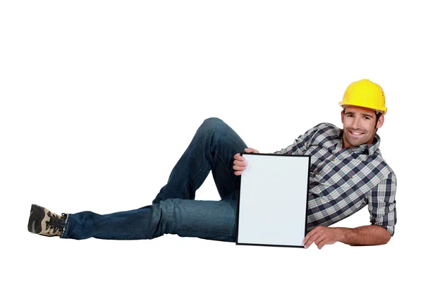 Trabalhador da construção deitado com uma placa deixada em branco para sua mensagem — Fotografia de Stock